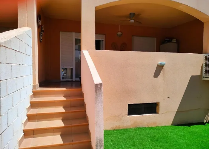 Bajo con jardín a pie de playa y piscina comunitaria con jacuzzi